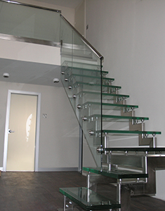 Стеклянное ограждение лестницы со стеклянными ступенями на боковых точечных креплениях
