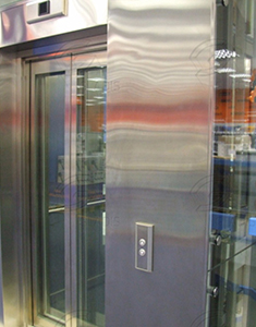 Примыкание стеклянных панелей к лифтовому порталу из нержавеющей стали